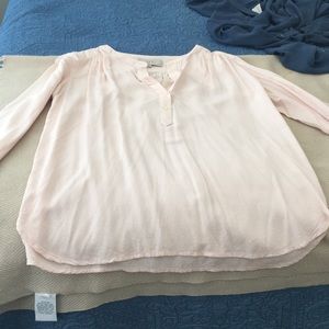 Button halfway down peach blouse